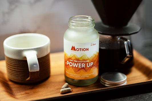 white and orange ceramic mug on brown wooden table
